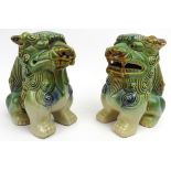 A matched pair of sandai glazed ceramic Buddhistic lions. Both of similar form with incised and