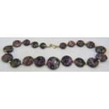 An unusual graduated tourmaline necklace consisting of 19 flat round tourmaline discs interspersed