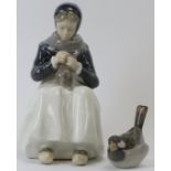 A large Royal Copenhagen figure of a young woman knitting in Amager attire. Designed by Lotte Benter