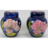 A pair of Walter Moorcroft magnolia pattern jars with covers. Tubline decorated flowers against a