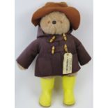 A large Paddington Bear, circa 1970s/80s. With brown duffle coat and hat with yellow boots and