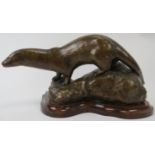 A bronze figure of an otter by Penny Wheatley, 20th century. Initialled P.W. Mounted on a wooden