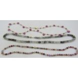 A multi coloured tourmaline bead necklace with small interspersed yellow metal beads on a 14ct