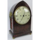 A Regency mahogany clock, 19th century. The mahogany case of gothic form with lion mask handles,