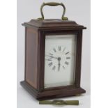 An Edwardian mahogany carriage clock. With a bevelled glass front and enamelled Roman numeral