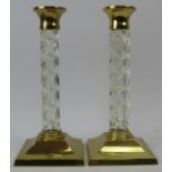 A pair of Waterford crystal candlesticks, 20th century. Faceted glass stems with brass sconces and