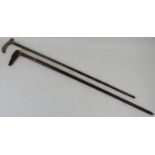 Two Edwardian walking canes. Comprising a walking cane with a tapered shaft mounted with two