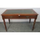 An Edwardian mahogany writing table with inset gilt tooled green leather surface, housing two
