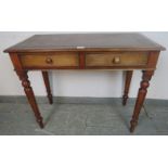 A Victorian mahogany writing table, with inset brown leather surface, housing two cock-beaded