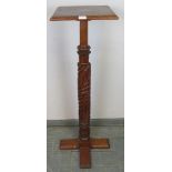 A 19th century walnut torchere, the chunky relief carved column on a quatreform base. Condition