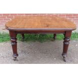 A Victorian mahogany wind-out extending dining table with three small additional leaves, on tapering