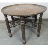 A large antique Benares table, the heavy gauge brass top depicting a multitude of figural and