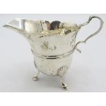 A silver cream jug with wavy edge decoration and hoof feet, London 1899. Approx weight 3.3 troy oz/