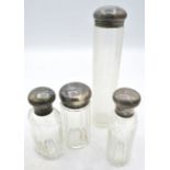 A collection of four panel cut travelling jars with silver tops, London 1909 & 1910. Condition