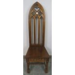 A well carved vintage oak steeple back hall chair in the Gothic taste, with carved pierced back