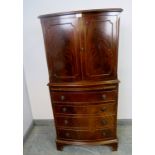 A vintage mahogany bow-fronted drinks cabinet in the Georgian style, the top section with double