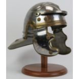 A Roman soldiers helmet, 20th century. Displayed on a wooden stand. 14.6 in (37 cm) height on stand.