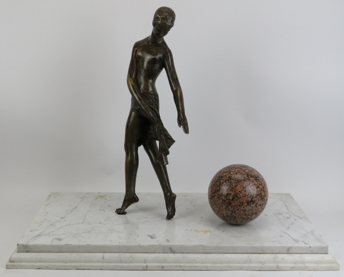 A large Neoclassical bronze and marble sculpture of a Grecian female with ball. The figure cast in