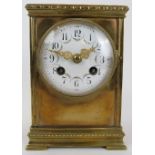 An Edwardian brass cased mantle clock. The enamelled dial decorated with floral swags. Key included.