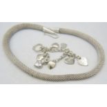 A white metal link bracelet marked 925 with eight heart shaped charms & a white metal heavy coil