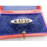 A 9ct gold bar brooch 'Baby', boxed. Approx weight 1.8 grams. Condition report: Some surface