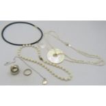 A fresh water pearl necklace with a mother of pearl circular pendant, on a silver ball clasp, boxed.