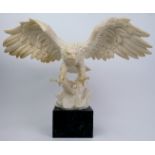 A composite cast statue of an eagle, 20th century. Signed to the reverse and displayed on a marble