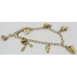 A delicate unmarked yellow metal charm bracelet with 9ct gold padlock clasp and six charms, some