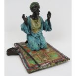 A cold painted bronze praying Arab, 20th century. 5.5 in (14 cm) length. Condition report: Good