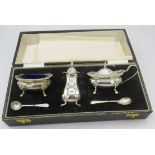 A three piece silver condiment set on pad feet, Birmingham 1969, with silver salt and mustard spoon,