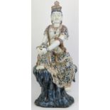 A large Chinese figure of Guanyin, 20th century. depicted seated on a rock with the figure painted