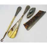 A silver nail buffer, a silver backed comb and a pair of silver handles buttons hooks & shoe horn.