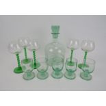 A green glass decanter with five short stemmed glasses and five long stemmed glasses with green