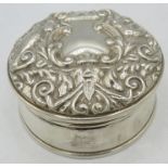 A silver trinket box in the Victorian style, embossed with mask, birds & scrolls, black velvet