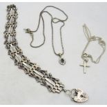 A silver gate link bracelet with silver padlock clasp, a small silver crucifix on a chain and a