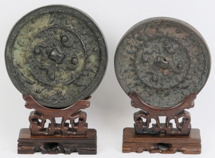 Two Chinese bronze mirrors. In the Tang dynasty style with decoration cast in relief depicting a