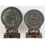 Two Chinese bronze mirrors. In the Tang dynasty style with decoration cast in relief depicting a