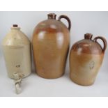 Two stoneware pots with stoppers, 50 cm and 35 cm tall and a large stoneware demi-john for