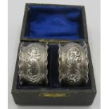 A pair of embossed silver napkin rings, Birmingham hallmarks worn, boxed. Approx weight 1.1 troy