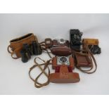 A group of vintage cameras and binoculars. (5 items) Condition report: Some wear with age. Bentley’s
