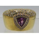 A heavy 18ct yellow gold ring set with centre pink trillion cut sapphire surrounded by bands of