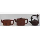 A group of three Chinese Yixing pottery teapots. (3 items) 5.6 in (14.2 cm) tallest height.