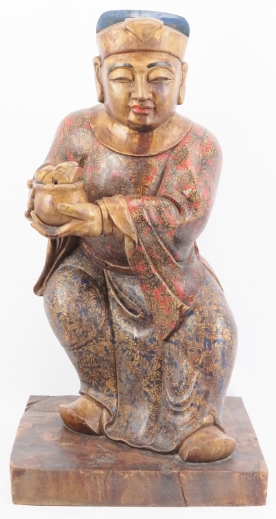 A Chinese gilt and lacquer painted carved wood figure, 20th century. Supported on a rectangular wood