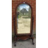 A Victorian mahogany arched cheval mirror, retaining the original nicely silvered plate, the