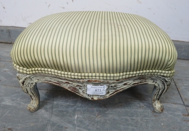 A small Victorian footstool, upholstered in period style striped material, the carved base painted