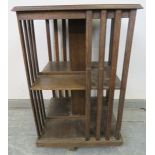 An Edwardian oak revolving book table of eight open shelves, with crossbanded top and slatted sides,