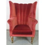 An antique barrel back porter’s armchair in the Georgian style, upholstered in crimson velvet