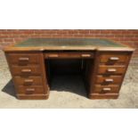 A large Edwardian oak reverse breakfront pedestal desk, the top with inset green leather writing