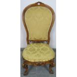 A Victorian walnut spoonback nursing chair, upholstered in gold damask material, on scrolled