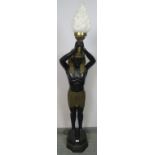 A vintage bronzed floor-standing lamp in the form of an Egyptian Pharaoh holding a torch aloft.